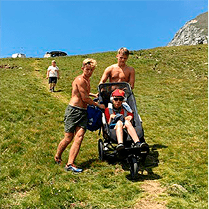 Andres and his brother helping him to mount the mountains in the european alpes in his Delta Push chair