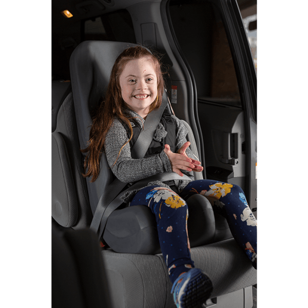 A girl enjoying sitting in the comfortable booster car seat.