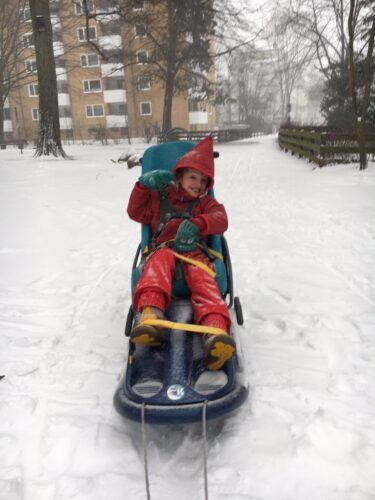 Rosali enjoys sitting in her sitter seat riding around in the snow